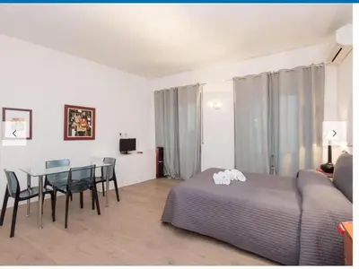a bedroom with a bed and a table and chairs at Natale del Grande flat in Rome