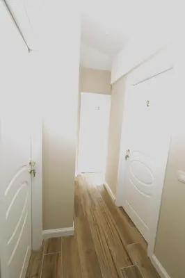 an empty hallway with white doors and wood floors at Sant'Erasmo Rooms in Rome