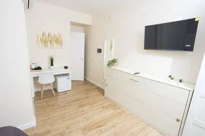 a living room with a desk and a tv on a wall at Sant'Erasmo Rooms in Rome
