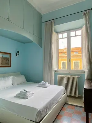 a blue bedroom with a bed and a window at Residenza Prati - ZEN24 in Rome