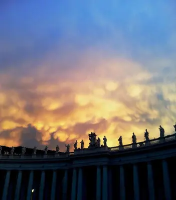 a cloudy sky with statues on the top of a building at Il Limone A San Pietro in Rome