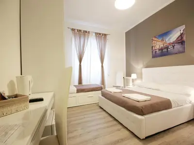 a bedroom with a bed and a desk and a window at Le Piazze Di Roma in Rome