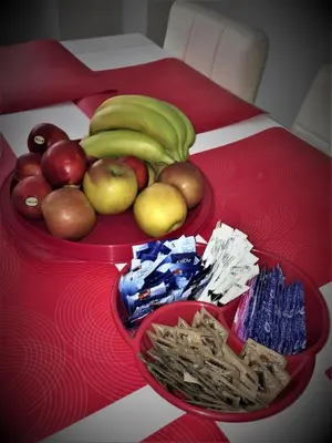 a red table topped with two bowls of fruit and snacks at Le Piazze Di Roma in Rome
