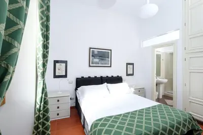a bedroom with a bed with a green and white blanket at Trastevere Charming Retreat on Cobblestone Street in Rome