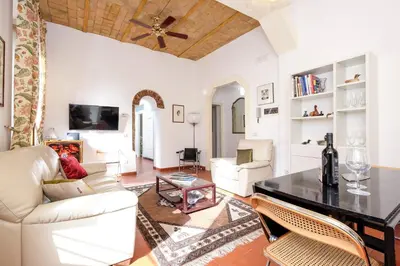 a living room with white furniture and a table at Trastevere Charming Retreat on Cobblestone Street in Rome