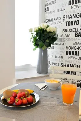a plate of strawberries and oranges on a table with orange juice at Maison Flaminio in Rome