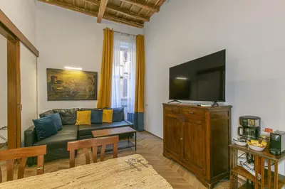 a living room with a couch and a flat screen tv at Trevi Little Palace #2 in Rome