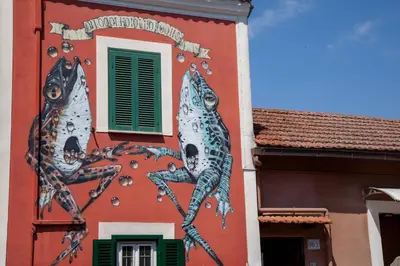 a painting of three fish on the side of a building at Casa Q163A Tuscolana Next to Metro in Rome