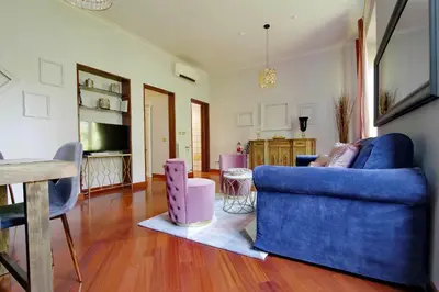 a living room with a blue couch and a table at Beautiful apartment with amazing Rooftop&Jacuzzi in Rome