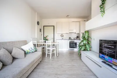 a living room with a couch and a kitchen at Urban Retreat -private parking+terrace in Rome
