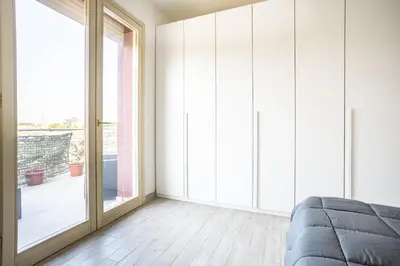 a bedroom with a bed and a large window at Urban Retreat -private parking+terrace in Rome