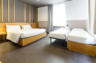 two beds in a hotel room with two bedsvisor at Central Lodge Hotel in Rome