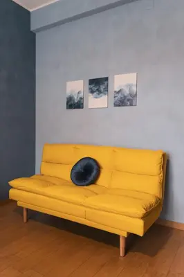 a black cat laying on a yellow couch in a room at Marconi 31 Rome Holiday House - Rome Vacation M&D in Rome