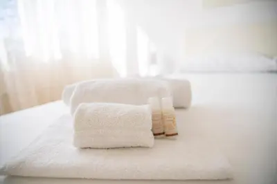 a pile of towels sitting on top of a bathroom counter at [Centro Storico-5min Vaticano] Domus in Rome