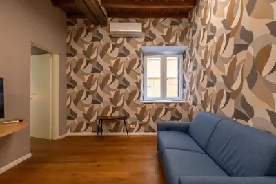 a living room with a blue couch and a window at Roma Centro Storico Luxury - Via del Corso in Rome