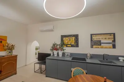 a kitchen with a counter with a sink and a table at Via Giulia Charming Atelier apartment in Rome