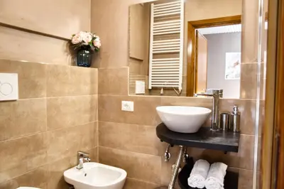 a bathroom with a sink and a toilet and a mirror at Di Martino Residence in Rome