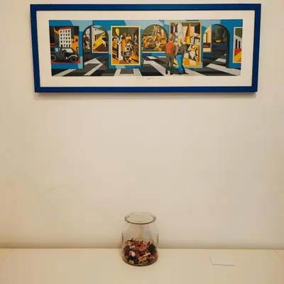 a picture hanging on a wall above a table with a glass jar at Oasi Urbana San Paolo in Rome