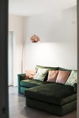 a green couch in a living room with a lamp at EasyTopStay - Stylish Flat with Garden in Rome