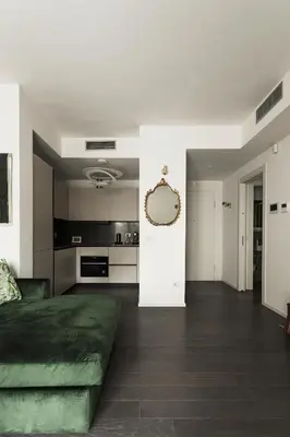 a living room with a green couch and a kitchen at EasyTopStay - Stylish Flat with Garden in Rome