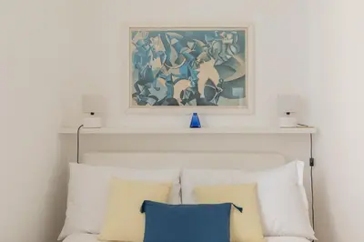 a painting above a white couch with pillows at iFlat Red Roman Apartament in Rome