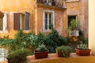 an old building with potted plants in front of it at iFlat Red Roman Apartament in Rome