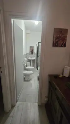 a bathroom with sinks and toilets and a hallway at Home Rome Center in Rome