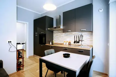 a kitchen with a table and a kitchen with black cabinets at VATICAN HOME ROMA in Rome