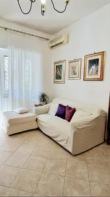 a living room with a white couch and a window at Giulia Home Apartment Metro Conca D'Doro Roma in Rome