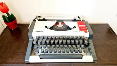 an old typewriter sitting on top of a wooden table at Giulia Home Apartment Metro Conca D'Doro Roma in Rome