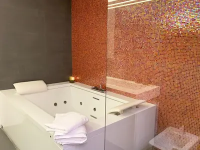 a bathroom with a bath tub with towels on it at ARCAsuite Tritone Luxury in Rome