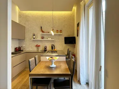 a kitchen with a wooden table and a dining room at ARCAsuite Tritone Luxury in Rome