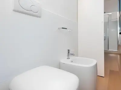 a white bathroom with a toilet and a sink at The Apartment at Spanish Steps in Rome
