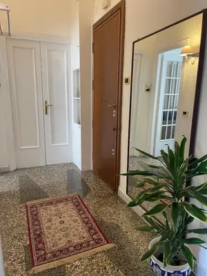 a hallway with a mirror and a potted plant at Brando Apartment in Rome