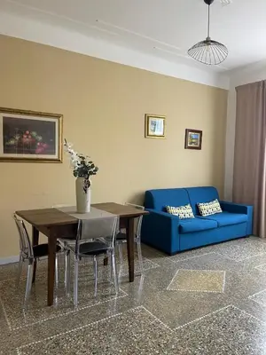 a living room with a table and a blue couch at Brando Apartment in Rome