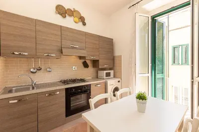 a kitchen with wooden cabinets and a table and a window at Turati by Rental in Rome in Rome