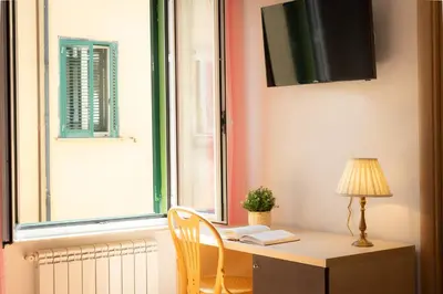 a desk with a lamp and a chair next to a window at Turati by Rental in Rome in Rome