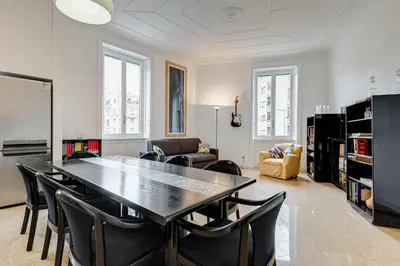 a living room with a dining room table and chairs at BMGA l Elegant Four-Room Apt for 8 Guests in Prati in Rome