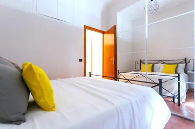 a bedroom with a white bed with a yellow pillow at Monti Colosseum in Rome