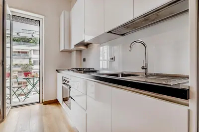 a kitchen with white cabinets and a sink at BBHOME Elegant apartment at Saint Peter front of Vatican in Rome