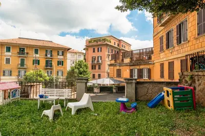 a group of chairs in the grass in front of buildings at Borghese Magnolia Suite in Rome