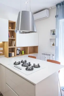a kitchen with a white counter with a stove top oven at Cozy flat with terrace at Trastevere train station in Rome
