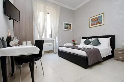 a bedroom with a bed and a table and a television at Domus Gallo Guest House in Rome
