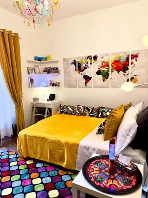a bedroom with a bed with a yellow bedspread and a table at Trastevere Gianicolense casa con giardino in Rome