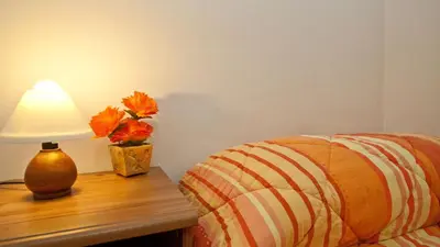 a lamp sitting on a table next to a bed at Rental in Rome Celeste Apartment in Rome