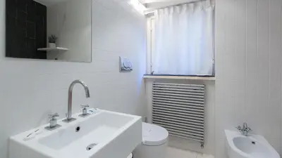 a white bathroom with a sink and a toilet at Rental in Rome Purificazione apartament in Rome