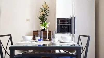 a dining room table with bowls and a microwave at Rental in Rome Trevi Fouintain View Apartment in Rome