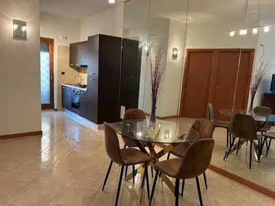 a kitchen and dining room with a glass table and chairs at Carpegna Luxury apt with terrace in Rome