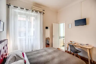a bedroom with a bed and a desk and a window at Circus Maximus B&B in Rome