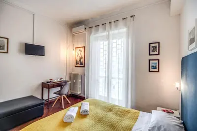 a bedroom with a bed and a desk and a window at Circus Maximus B&B in Rome